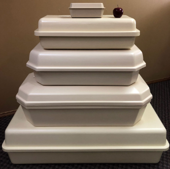 Stacked white takeout containers with a red apple on top, arranged in a pyramid on a carpeted floor.