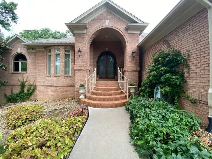A brick house with stairs leading up to the front door