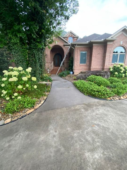 A brick house with a concrete driveway leading to it
