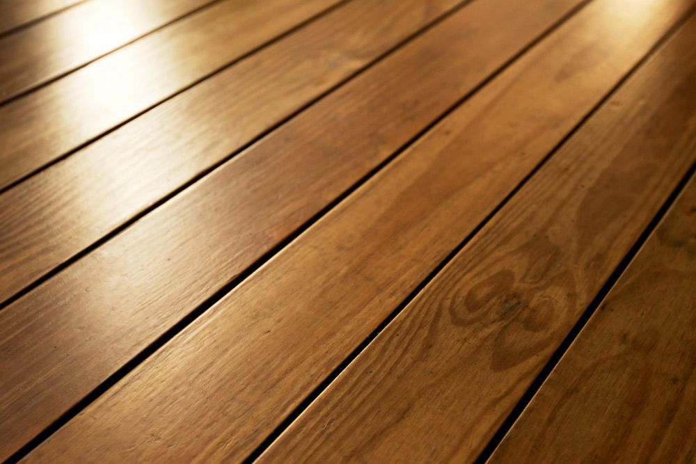 A Close Up Of A Wooden Floor With The Sun Shining Through It — Affordable Carpets Woolgoolga In Woolgoolga, NSW