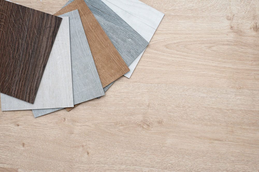 A Stack Of Samples Of Different Types Of Vinyl On A Table — Affordable Carpets Woolgoolga In Northern Rivers, NSW