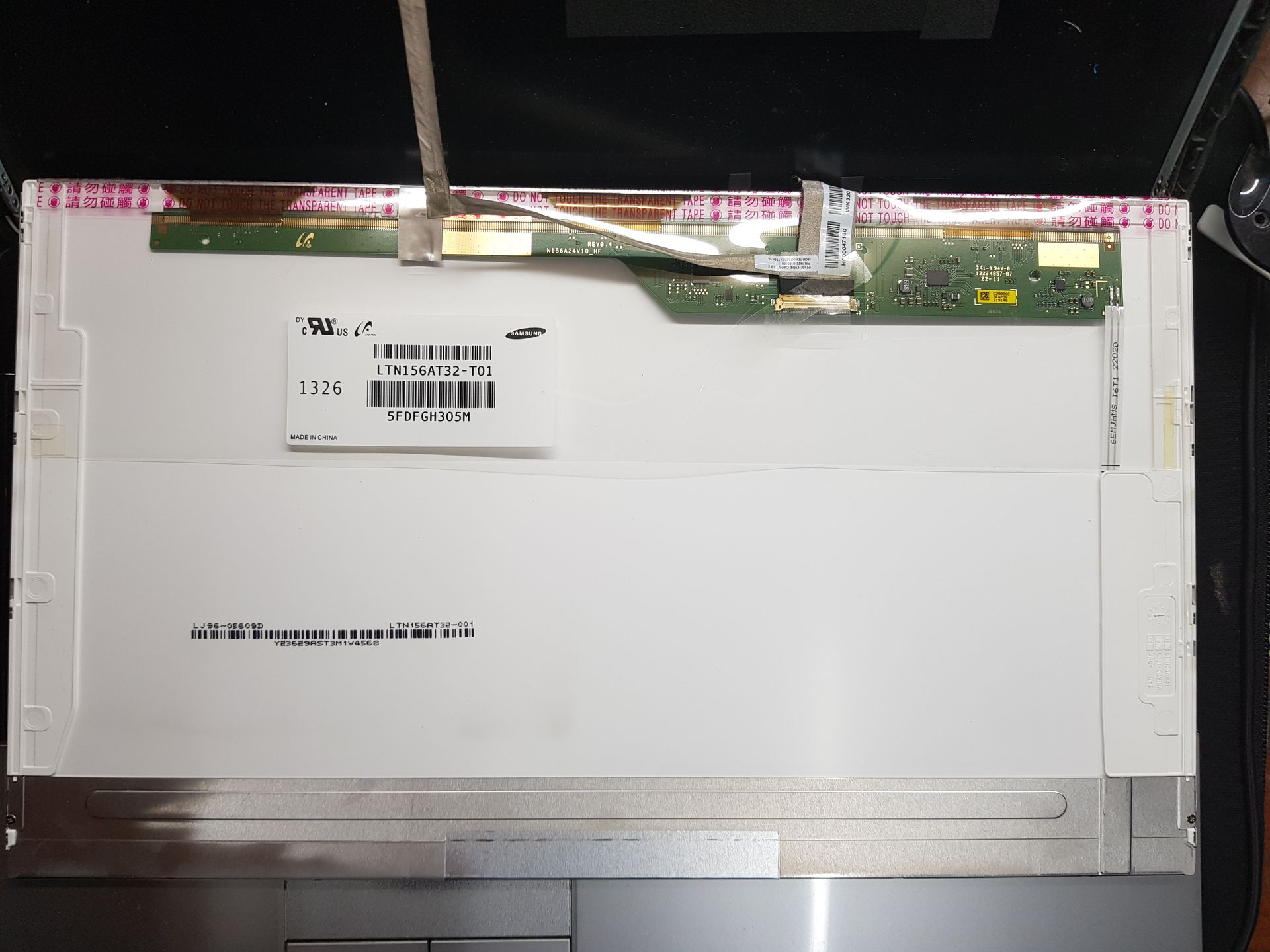 Pantalla de notebook vista desde atrás con etiquetas y flex – cambio de pantalla en Bahía Blanca.