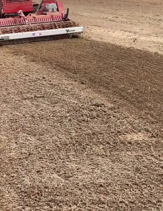 A machine is moving dirt in a field.