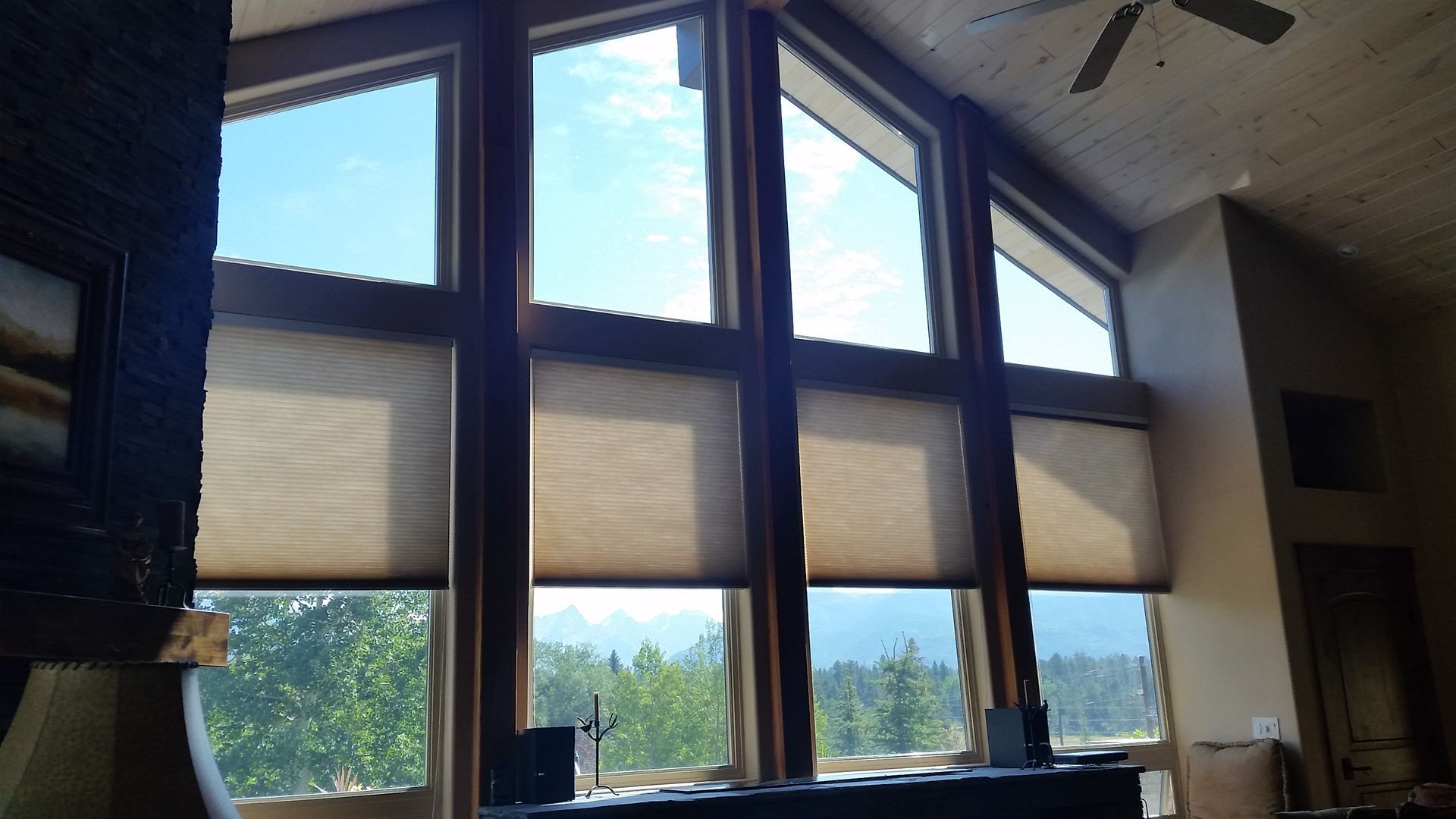 a living room with a huge window with cellular shade