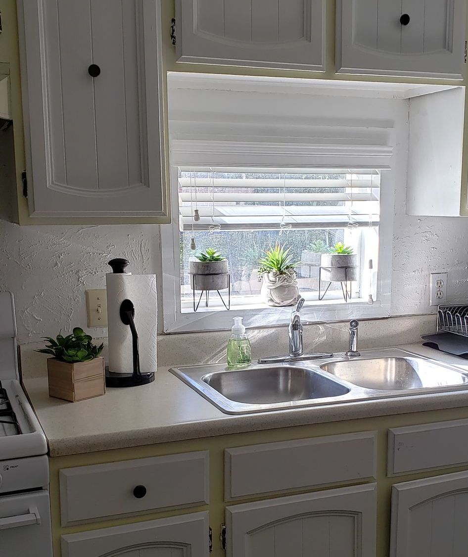 a kitchen with wood blinds on window 