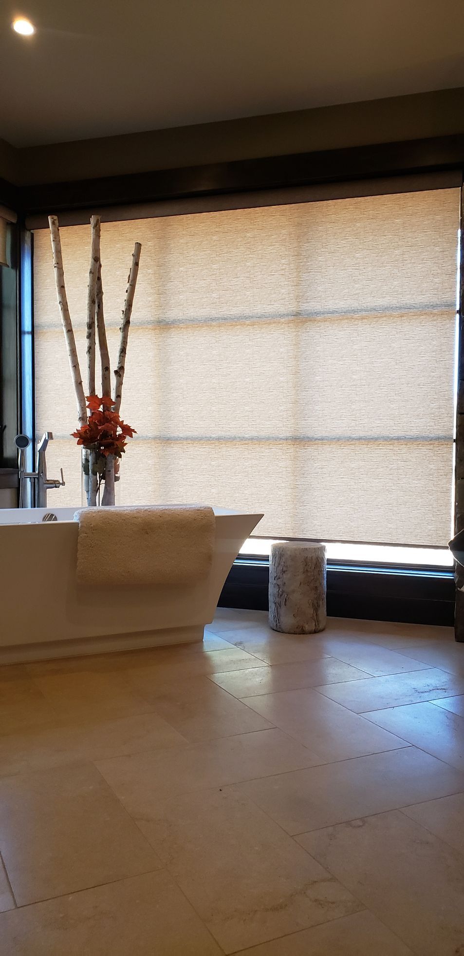 a bedroom with a bed and a window with solar shades