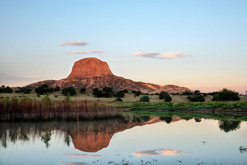 a mountain is reflected in a body of water at Blanco, New Mexico
