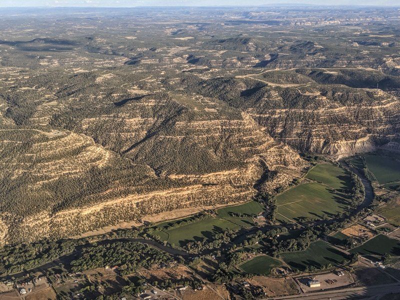 an aerial view of a valley with mountains and a river at Cedar Hill, NM