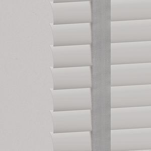 a close up of a white aluminum blind with cloth tape on a window .
