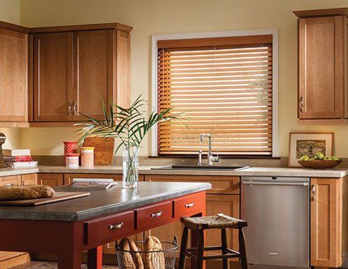 A kitchen with Faux Wood Blinds on the window above the kitchen sink