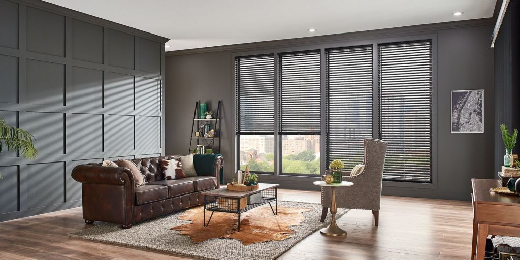 a living room with Faux wood shutters on the windows