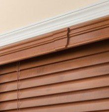 a close up of a keystone wooden blind on a window .