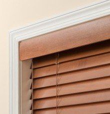 a close up of a optional crescent valance wooden blind on a window .