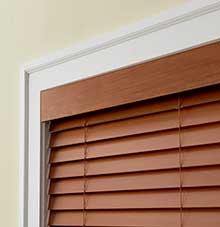 a close up of a wooden optimal modern valance & blind on a window .