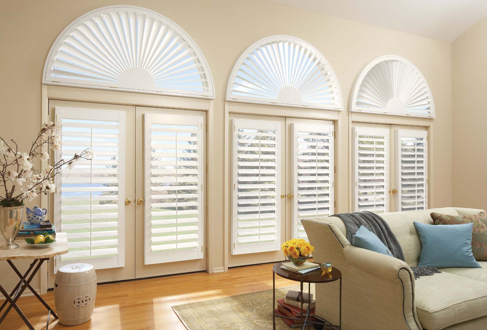 A living room with a couch and shutters on the windows