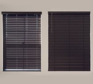 two black wooden blinds are hanging on a window next to each other .