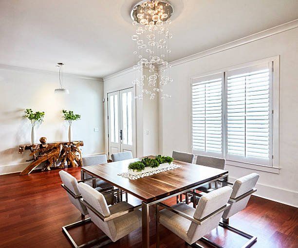 a dining room with a wooden table and chairs and a chandelier .
