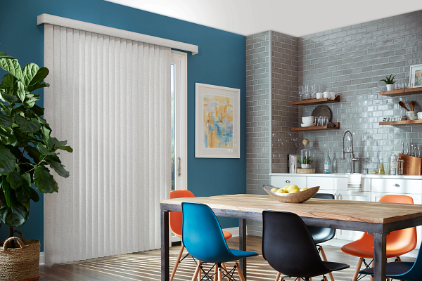 A dining room with a table and chairs and a blue walls and a vertical blinds installed on the window.