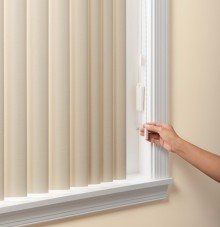a person is opening a window with vertical blinds using standard chain and cord control