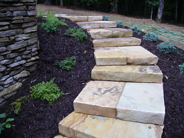 A row of stone steps leading up to a stone wall