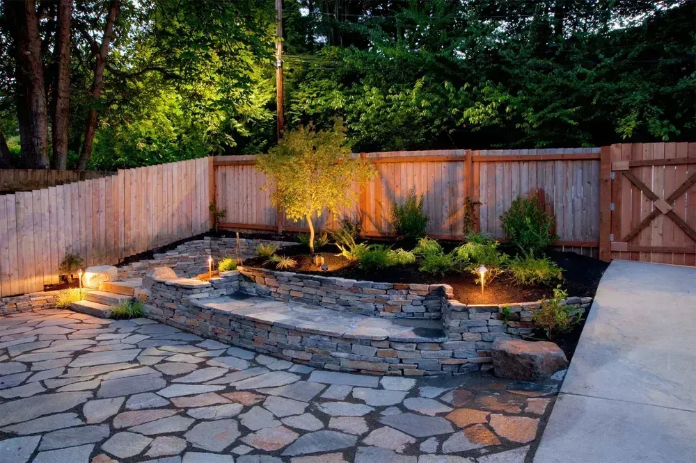 A stone patio with a wooden fence in the background