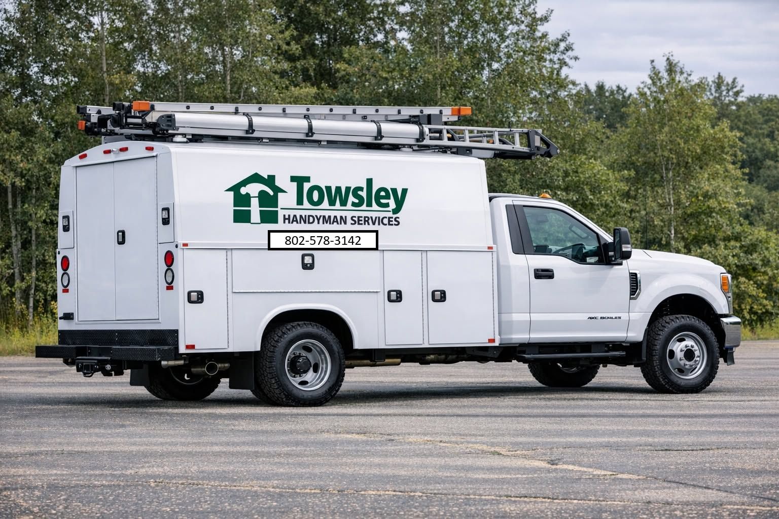 White Towles service truck with ladder rack parked outdoors on pavement.
