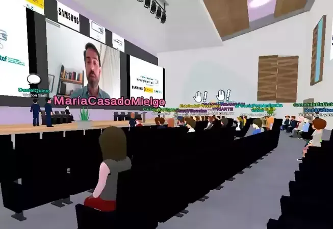 Virtual conference: speaker on screen, avatars in audience, stage, and event space.