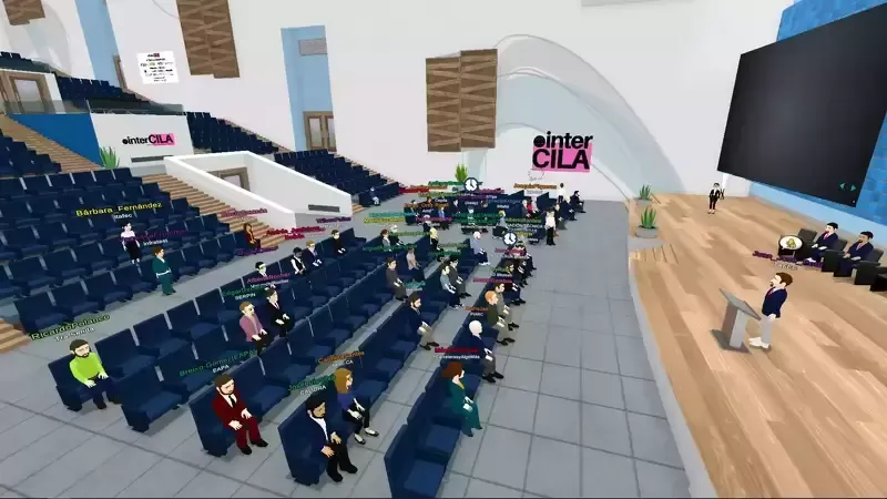 Audience in a large auditorium with a speaker at the podium;