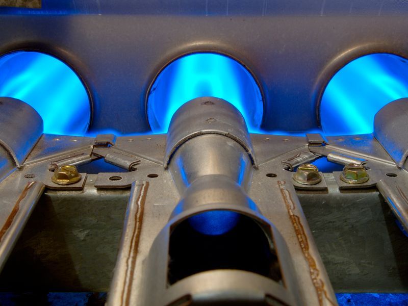 A close up of a burner with blue flames coming out of it