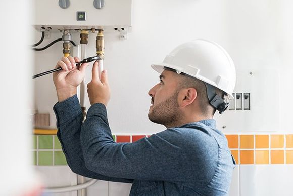 Repairman Installing a Natural Gas Boiler at a House — Croydon, PA — Jed Plumbing LLC Repairman Installing a Natural Gas Boiler at a House — Croydon, PA — Jed Plumbing LLC