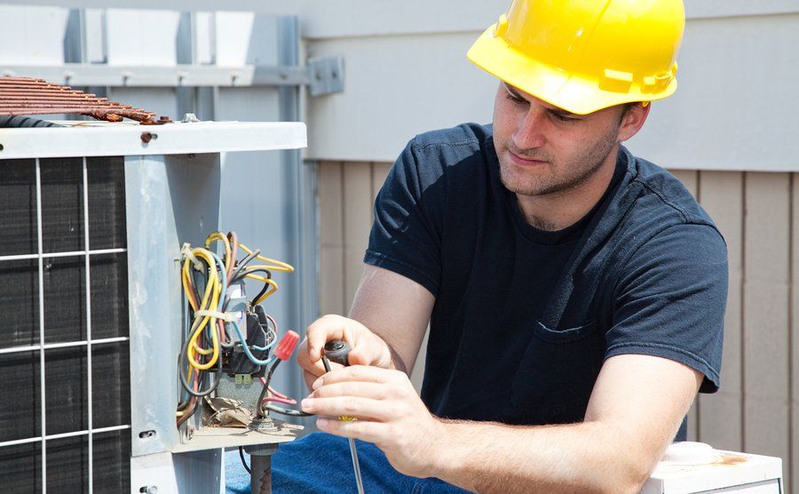hvac technician repairing heat pump