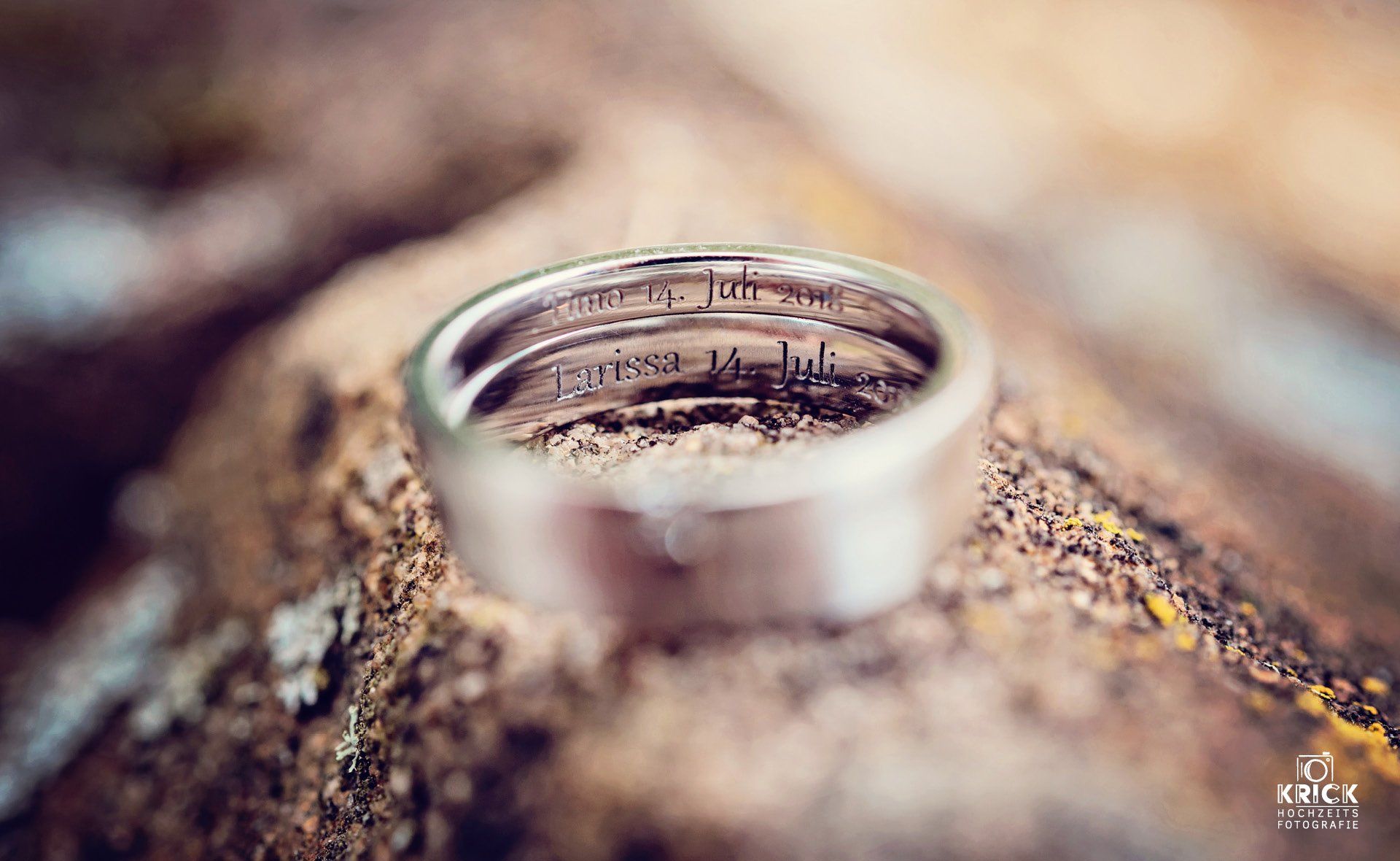 Nahaufnahme eines silbernen Rings, der auf einer strukturierten Baumrinde liegt
