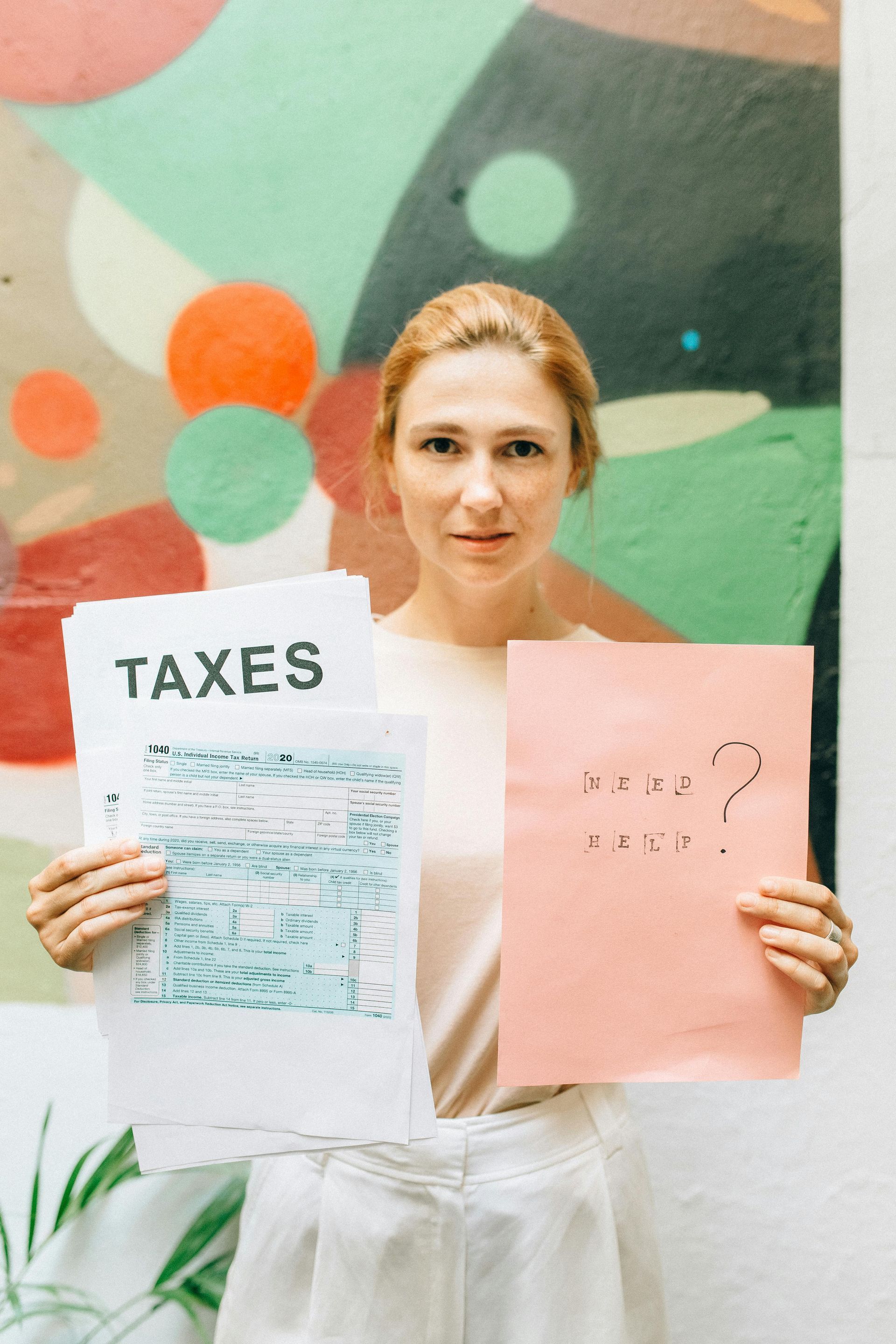 Woman holding tax forms and a pink paper that says