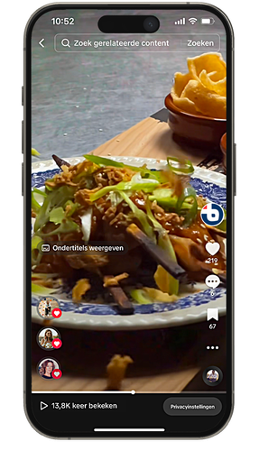 Smartphone waarop een TikTok-video te zien is van een bord eten, mogelijk noedels, met gefrituurde chips op de achtergrond.