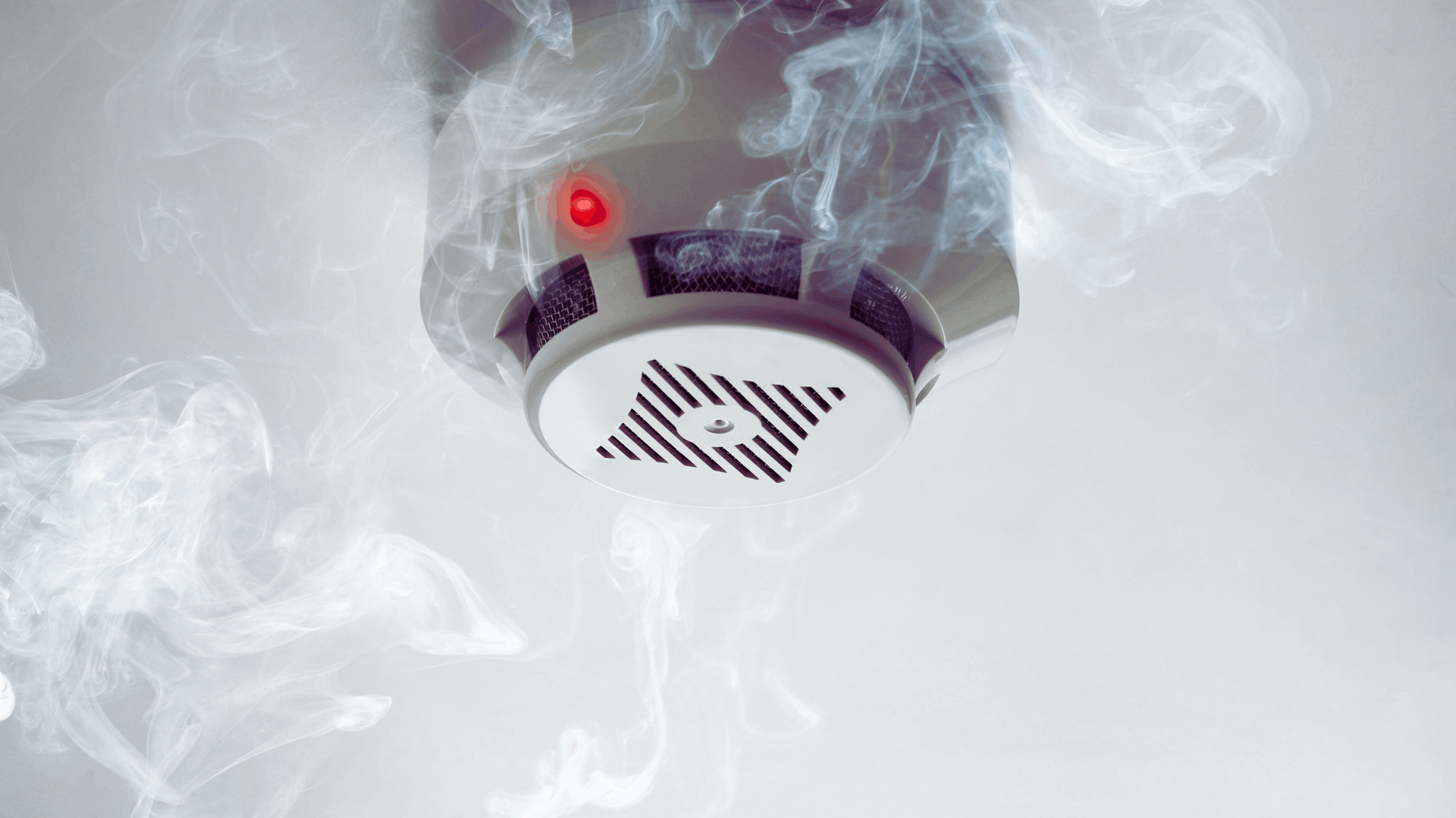 Smoke-filled room, smoke detector with red light activated, ceiling — Chayser Electrical in Currimundi, QLD