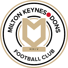 Milton Keynes Dons Football Club circular logo in black, white and gold with red dot accents