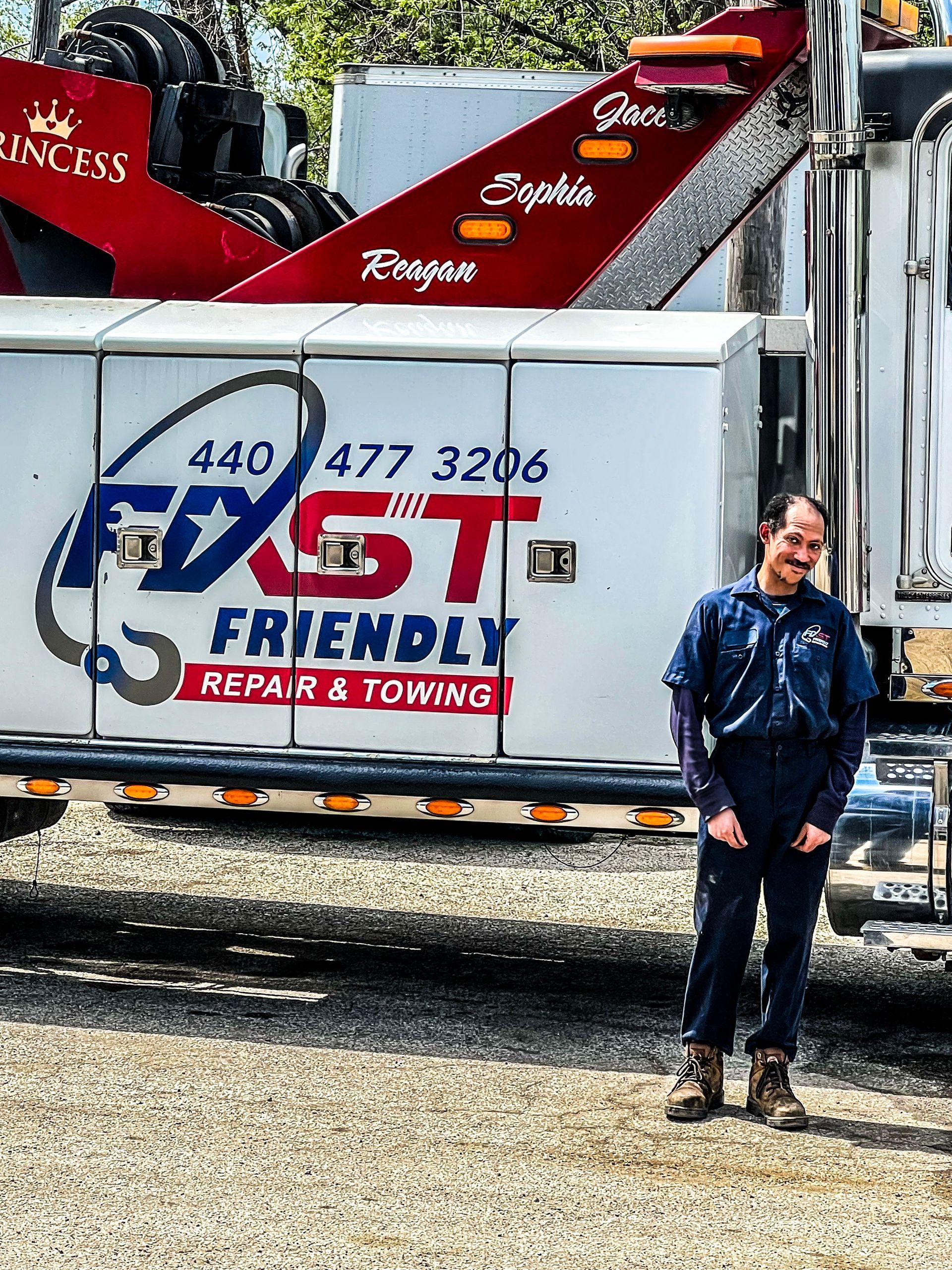 A man is standing in front of a truck that says Fast Friendly Repair & Towing.