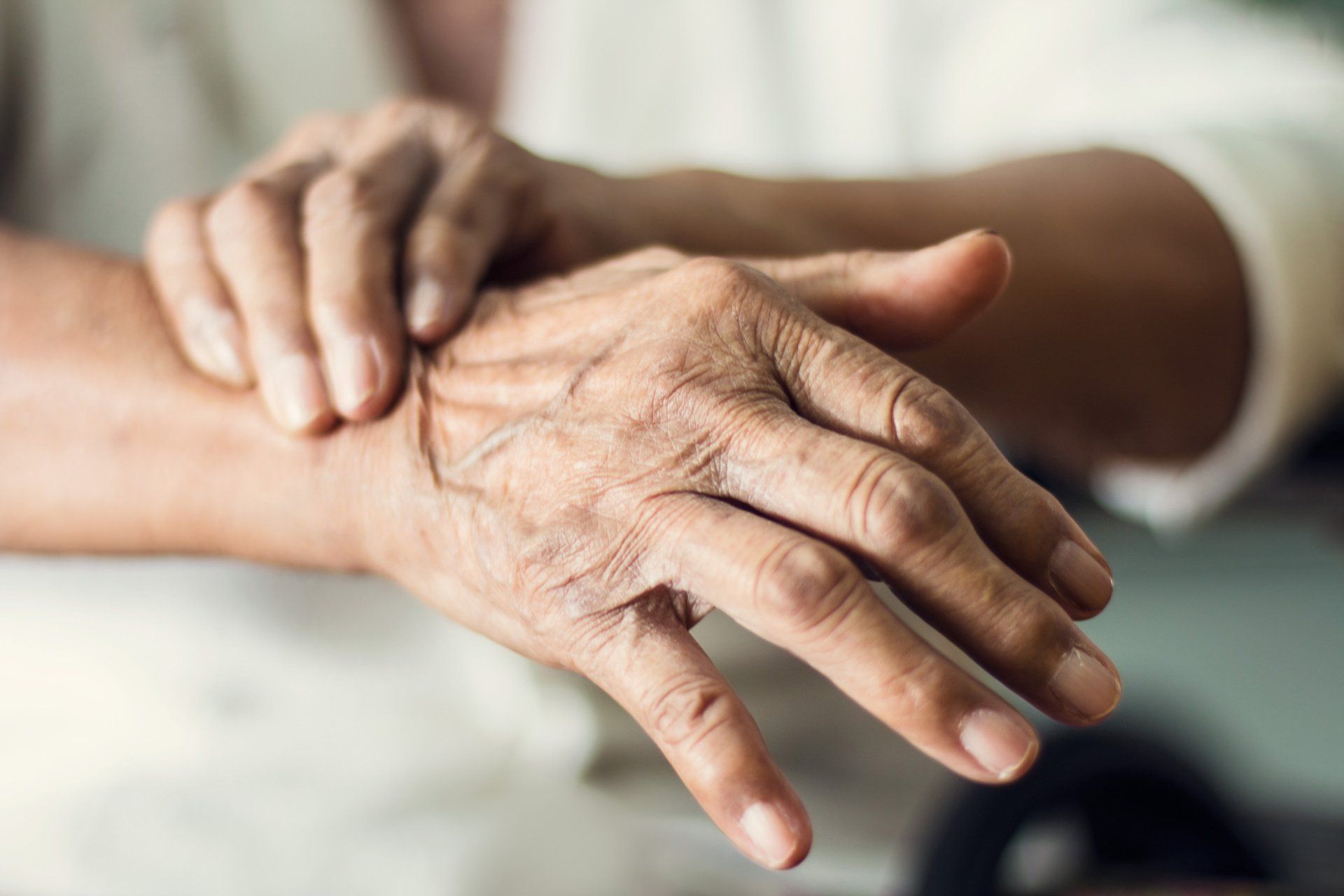 A close up of a person holding another person 's hand.
