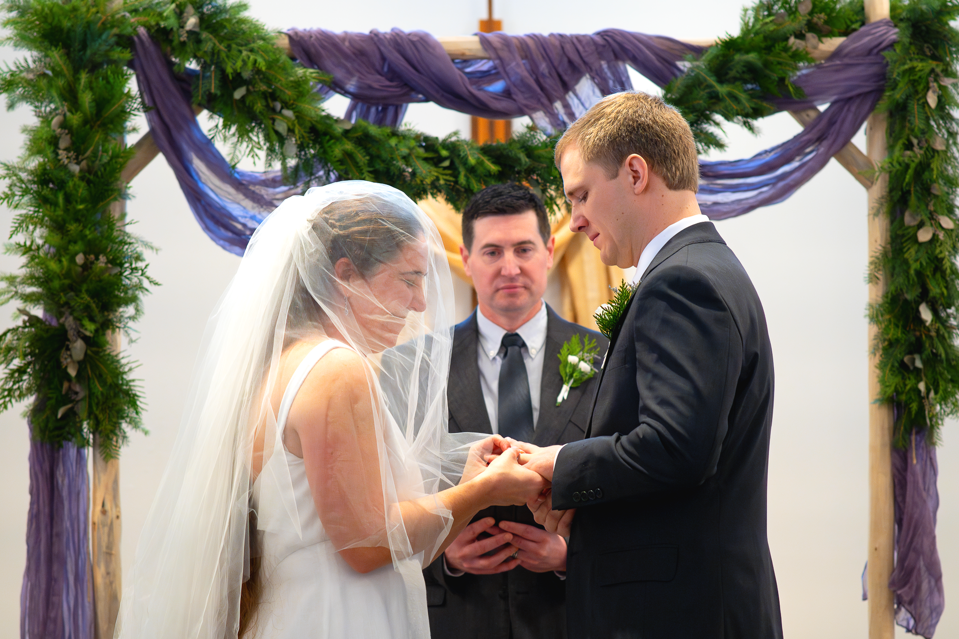 Bride and groom exchanging rings at church alter