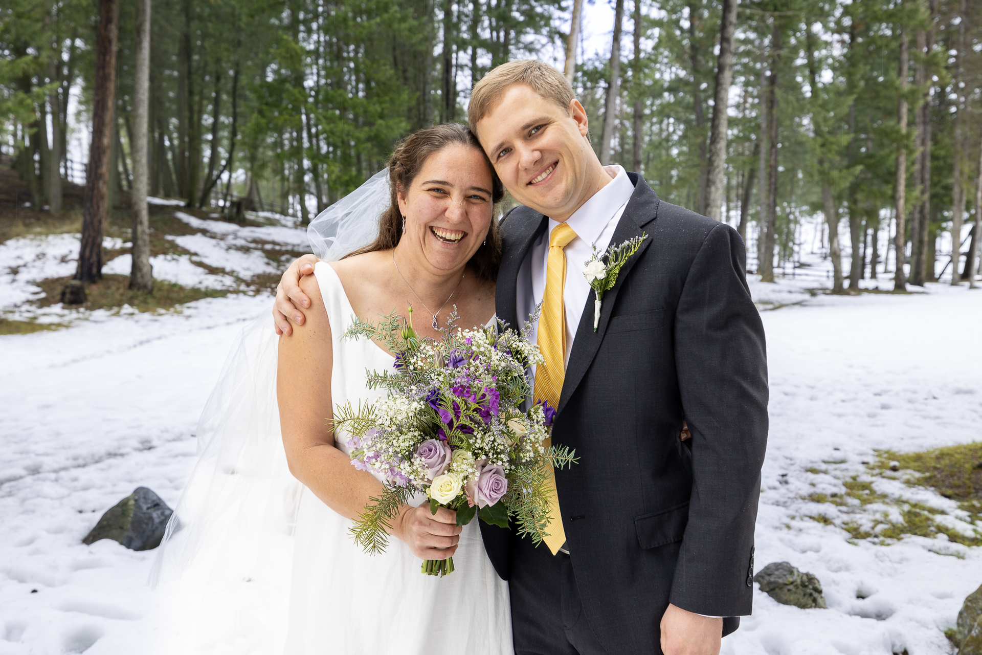 A happy married couple posing in the woods