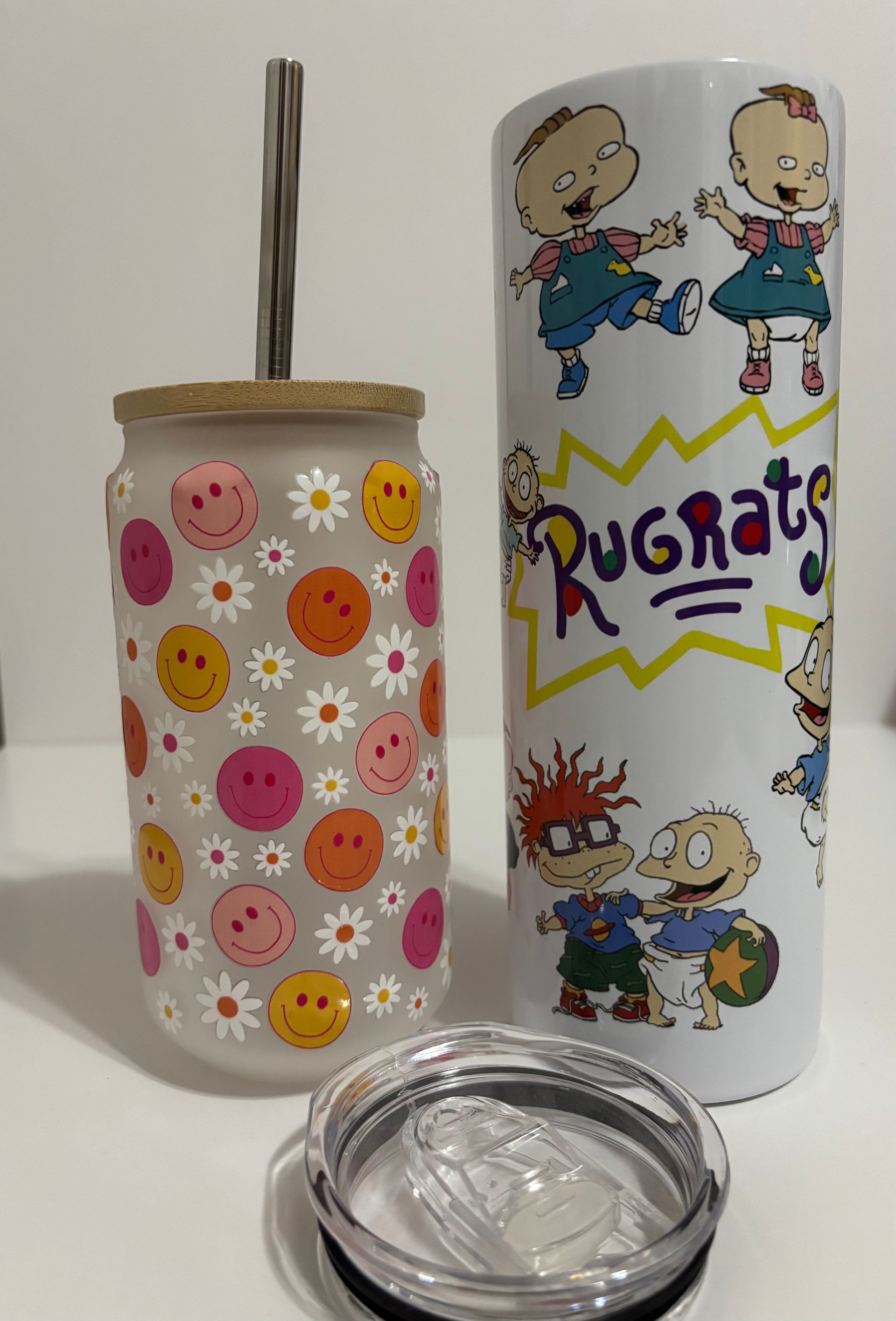 White tumbler with black logo and metal straw in front of a hot air balloon backdrop