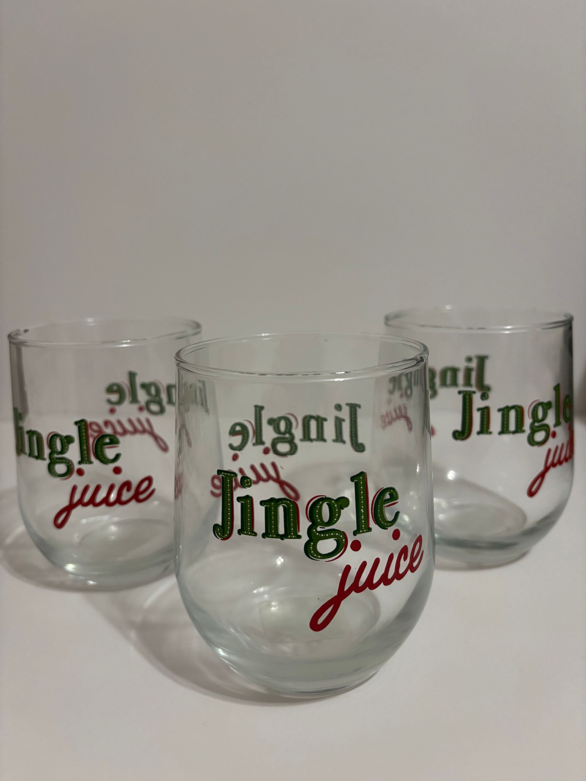 Four clear stemless glasses with 
