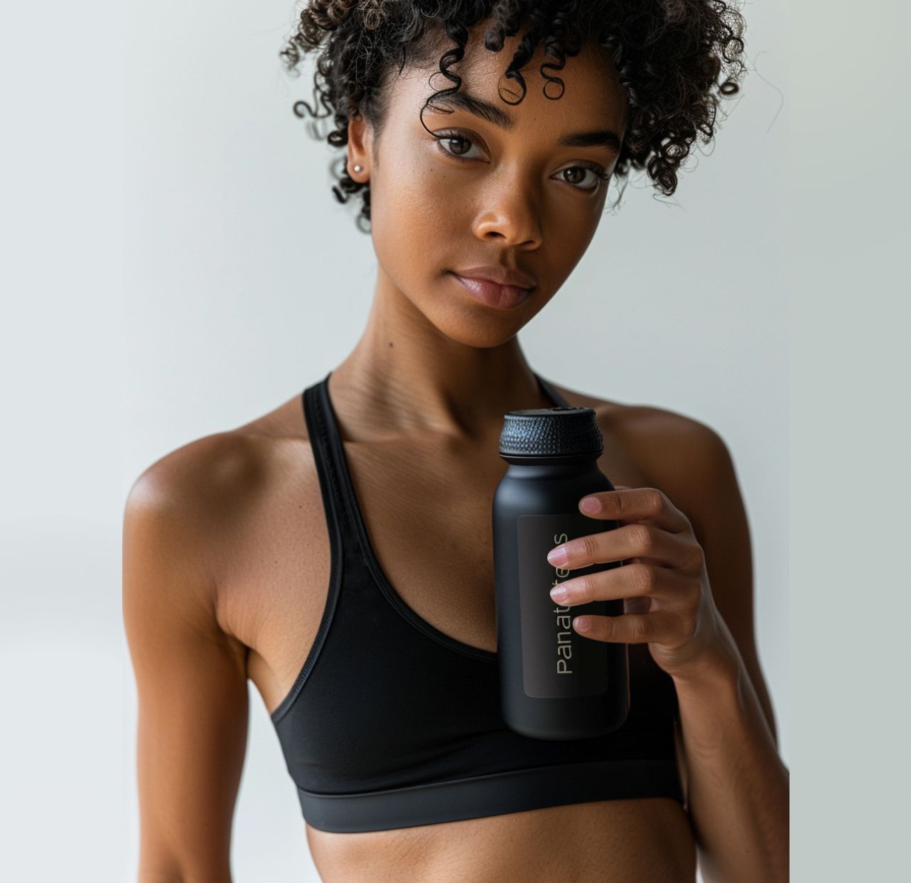  black athletic wear holding a black water bottle