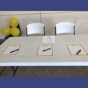 A table with three pens and papers on it