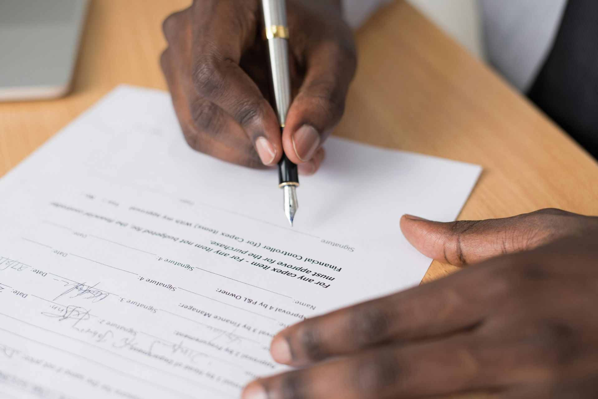 A person is writing on a piece of paper with a pen.