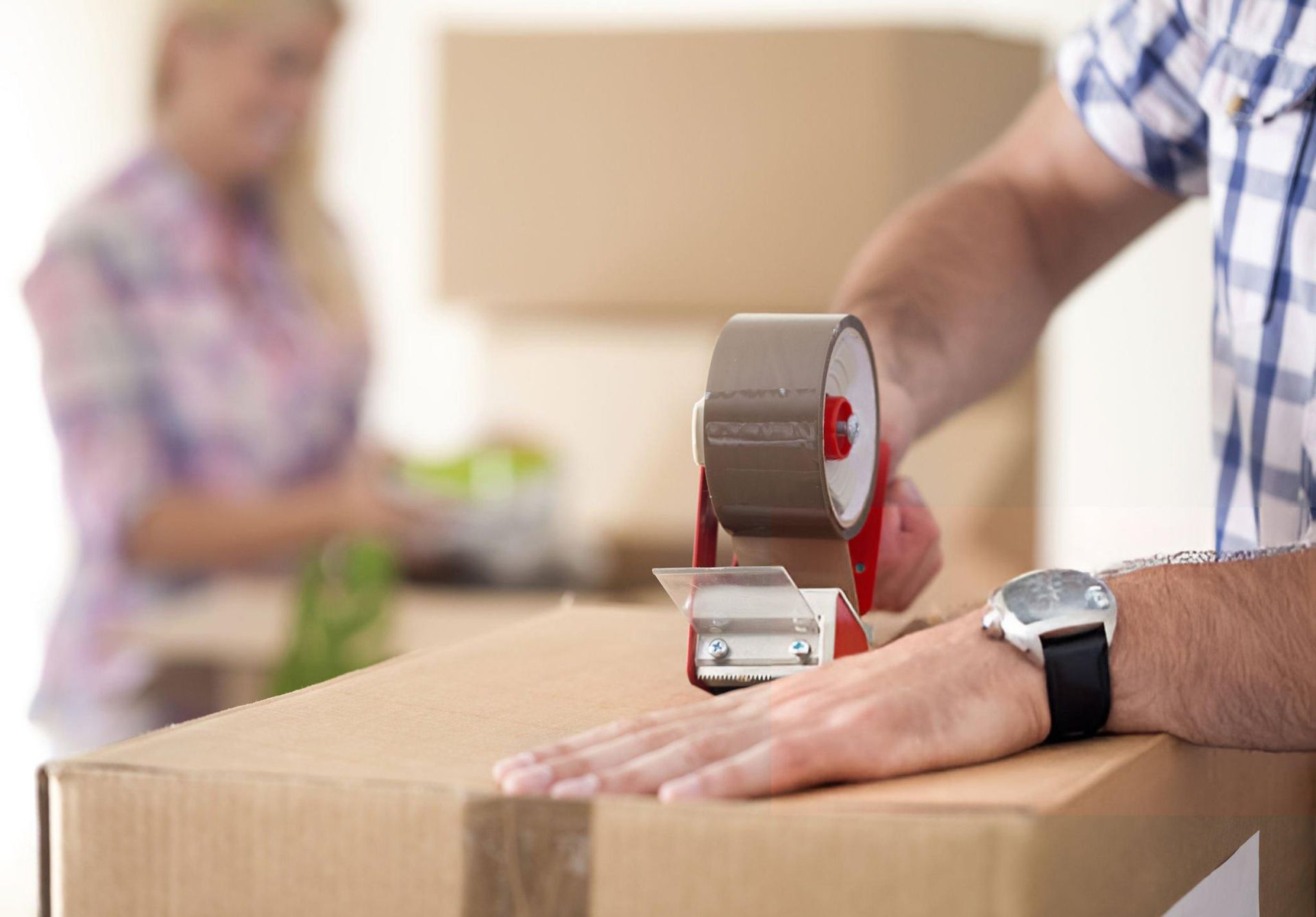 Male senior moving service professional from Redondo Van, in Torrance, CA, seals a client’s box