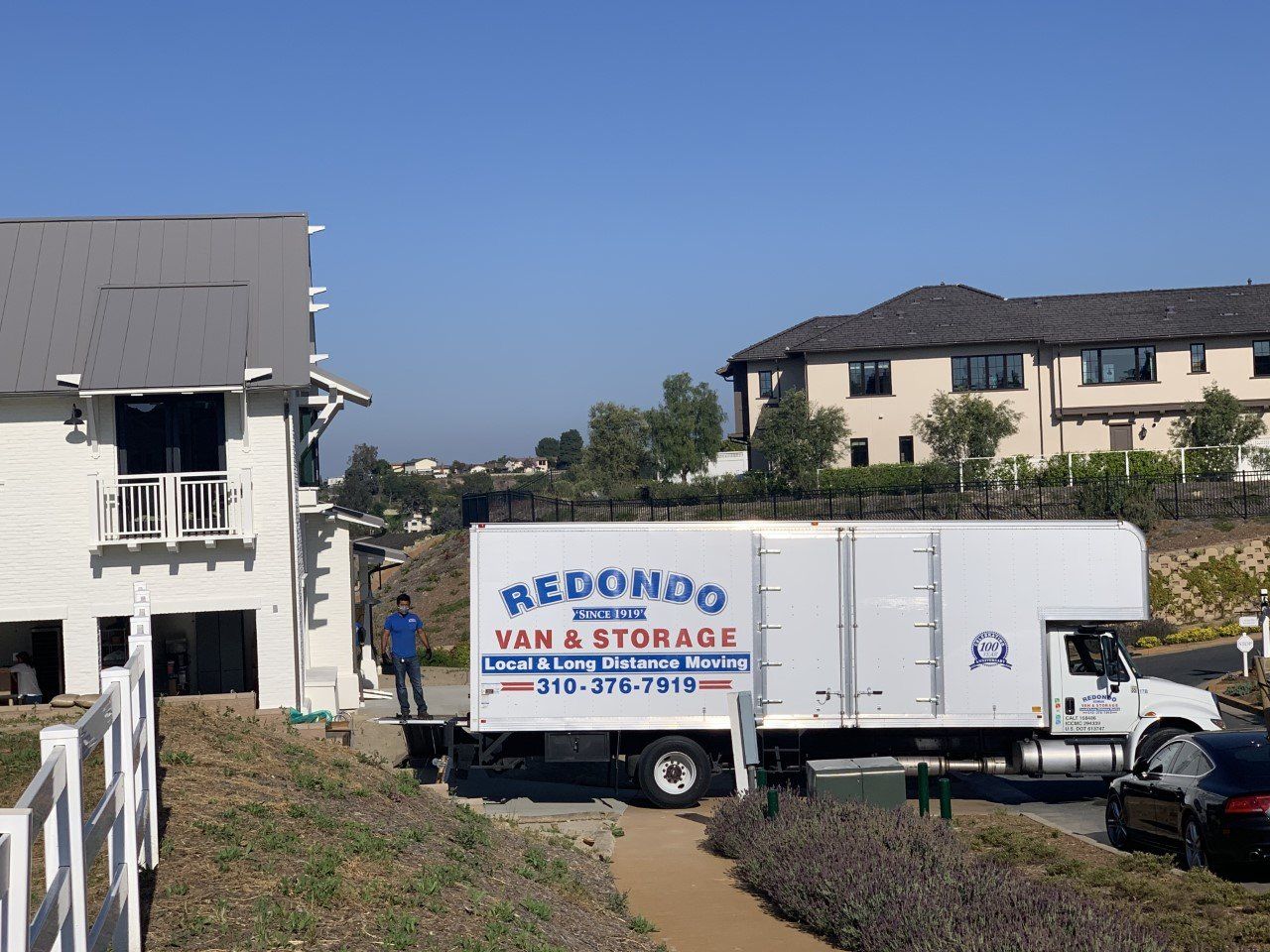 Redondo Van & Storage truck parked between buildings on a sunny day