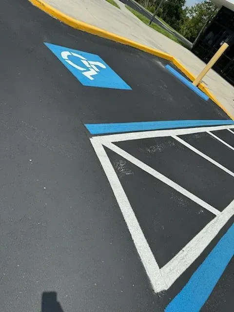 Accessible parking space with blue wheelchair symbol and white striped access aisle in a lot