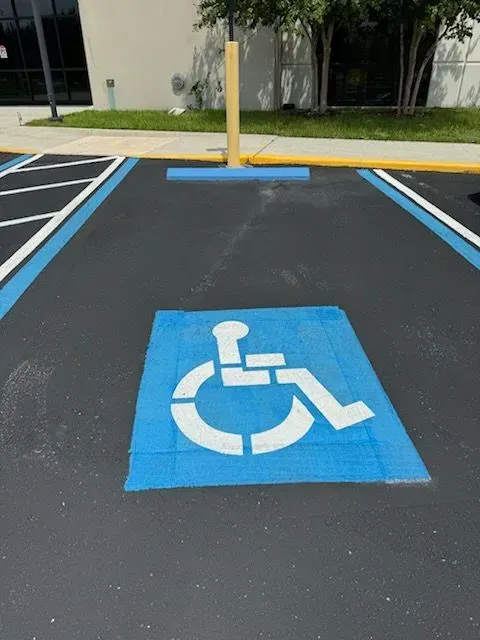 Blue accessible parking space with wheelchair symbol painted on asphalt.
