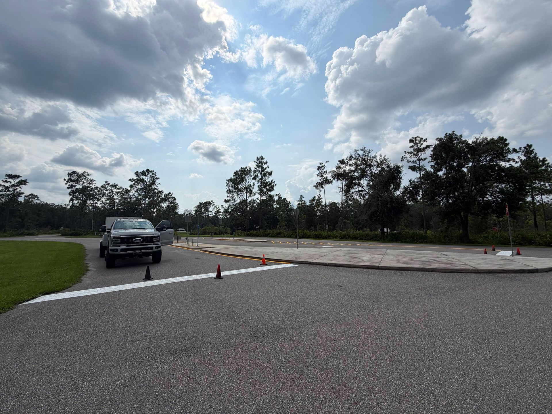 SUV on a paved test track with traffic cones under a cloudy sky